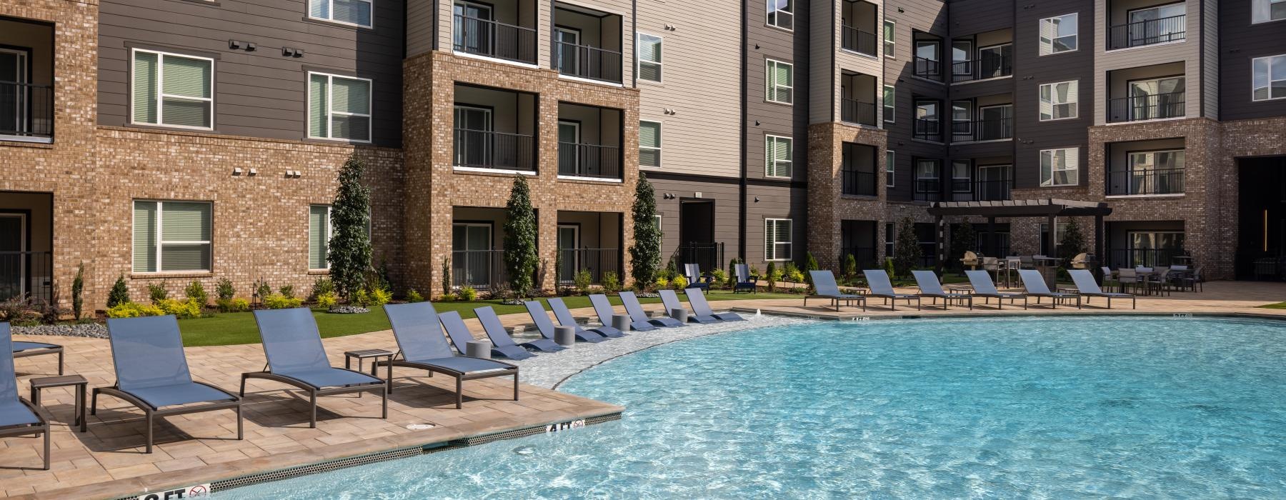 a swimming pool with chairs around it