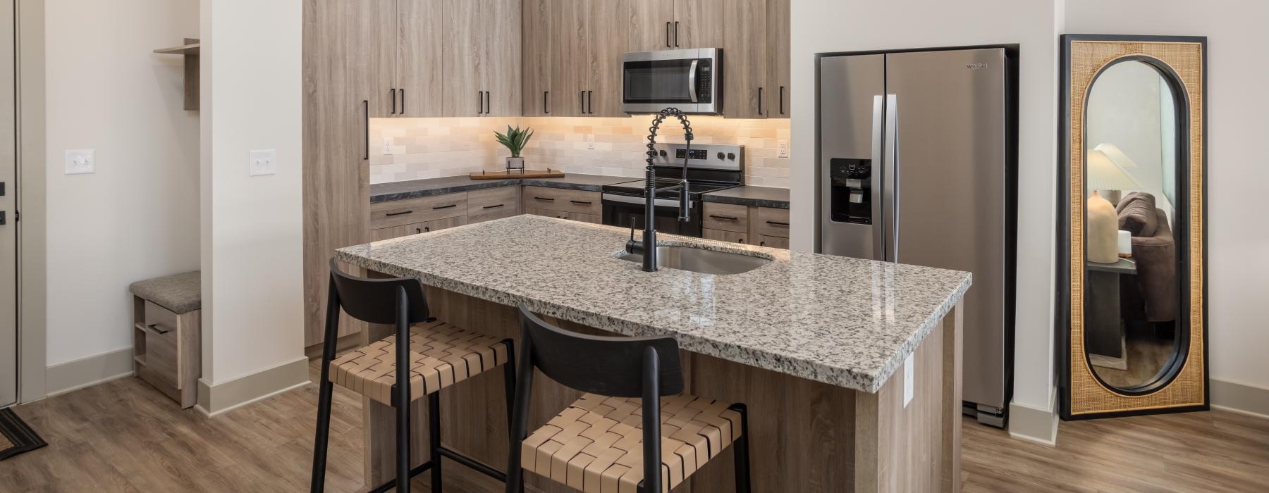 a kitchen with a island bar and granite countertops