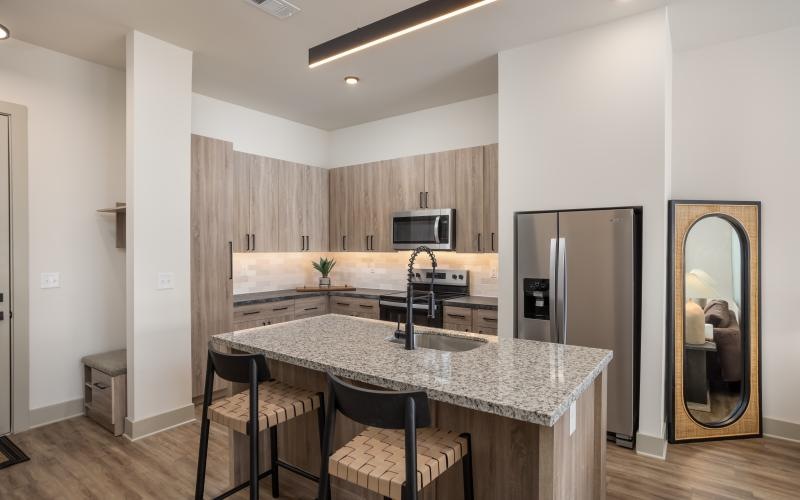 a kitchen with a island bar and granite countertops