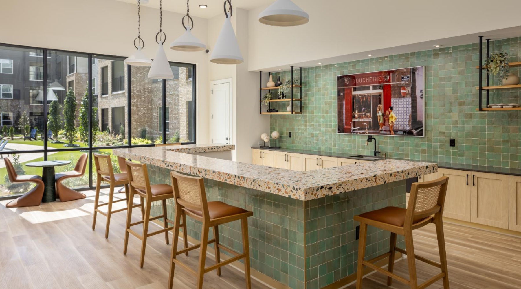 a kitchen with a bar and chairs and green tiling