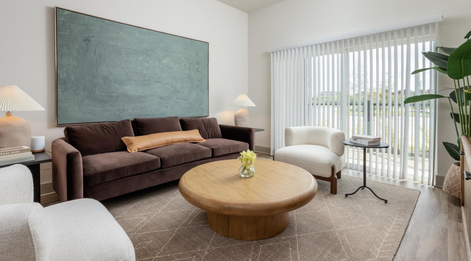 a living room with a large couch and a table and large glass door